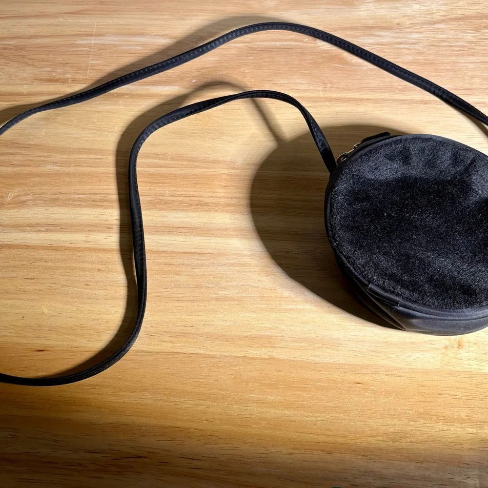 Women’s Round Black Crossbody Bag with zipper closure.